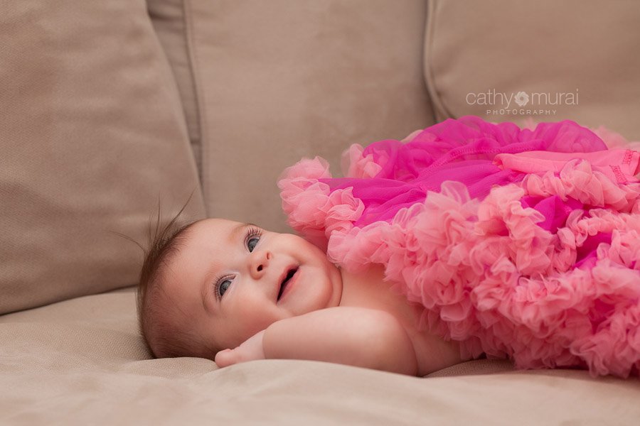A cute baby with a smile on the sofa - Captured by a Glendale Lifestyle Pet Photographer, a Glendale Baby Photographer, a Glendale Family Photographer, Cathy Murai Photography