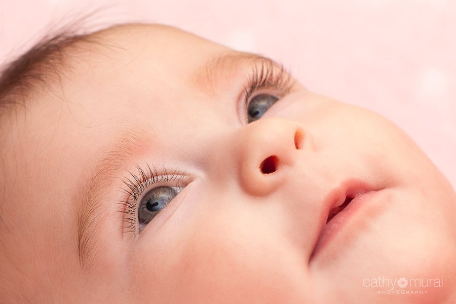 An adorable baby with beautiful eyes and long lashes in her nursery room - Captured by a Glendale Lifestyle Baby Photographer, Cathy Murai Photography