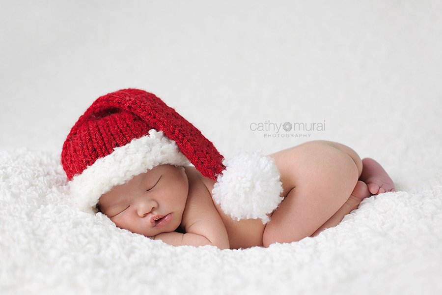 Newborn Baby Girl wearing Santa Hat during on-location Newborn portrait session in Santa Fe Spring, CA