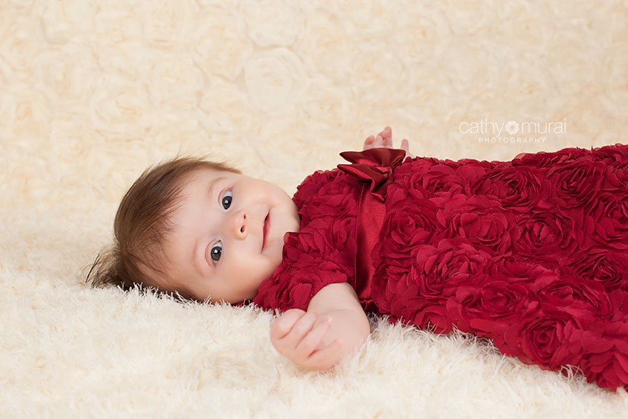 3 months old baby girl with beautiful eyes looking at the camera at her Valentine's Day Session 