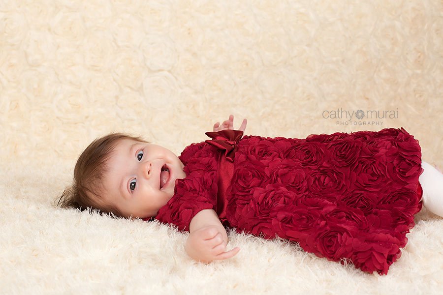 3 months old baby girl wearing a beautiful Valentine's Day dress at her Valentine's Day Baby portrait session 