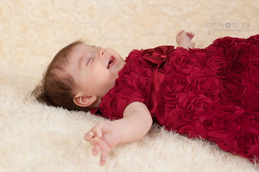 Adorable happy baby laughing during her 3 months old portrait session