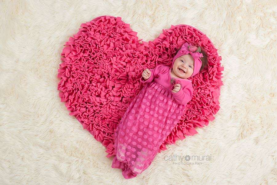 Adorable 3 months old Baby Girl smiling and laughing on the heart shaped carpet during her 3 months old portrait session / Valentine's Day Portrait Session  