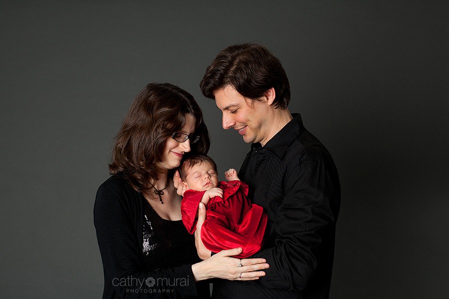 Family Christmas Portrait session with a 1 month old newborn baby girl wearing a beautiful Christmas red dress