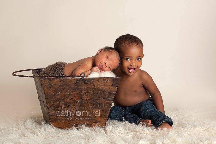 Brotherly love, siblings portrait, siblings shot, sibling photography, African American baby boy sleeping and posing in the wooden prop next to his older brother - taken by  Alhambra Newborn and Baby photographer, Cathy Murai Photography, Los Angeles Newborn and Baby Photographer