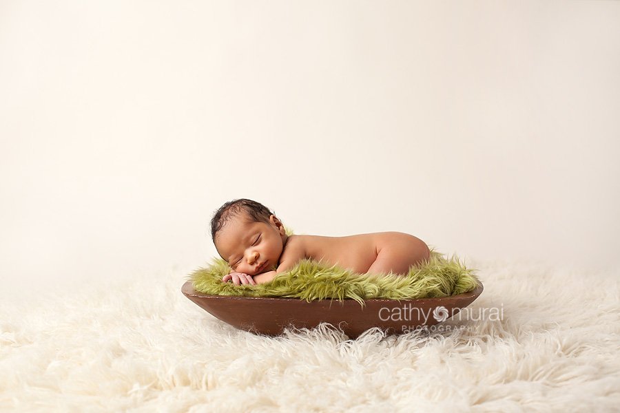 African American baby boy sleeping and posing on the green fur with cream background - taken by  Alhambra Newborn and Baby photographer, Cathy Murai Photography, Los Angeles Newborn and Baby Photographer