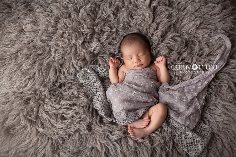 Asian 2 weeks newborn baby girl wrapped by grey wrap posing and sleeping on grey float rug. Alhambra, San Gabriel Valley, Los Angeles, CA  Studio Newborn Photographer, Cathy Murai Photography 