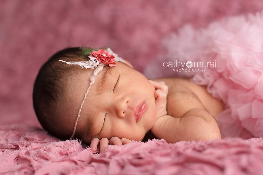 Newborn baby girl wearing a pink pettiskirt and headband, posing while sleeping, picture, image, portrait - captured by Los Angeles Newborn Photographer, Cathy Murai Photography