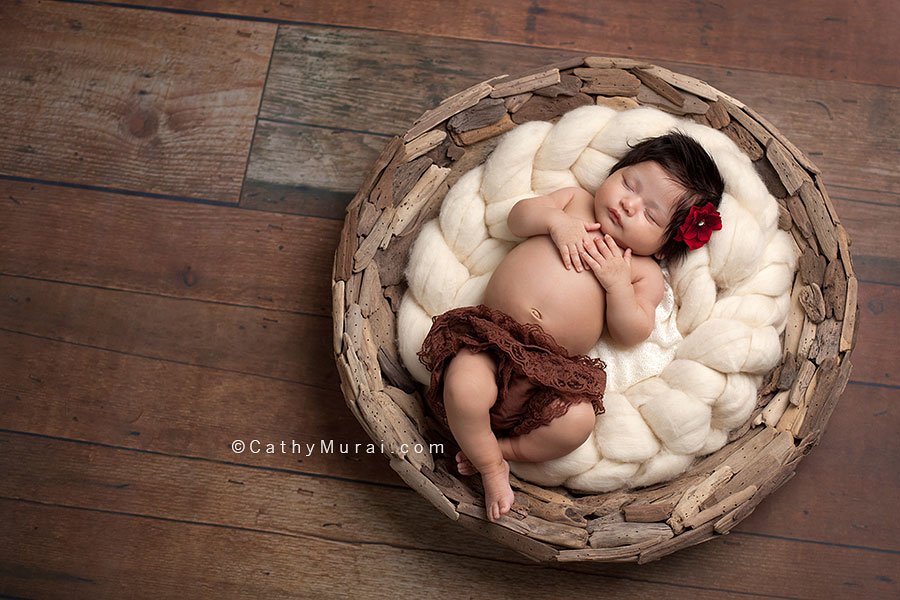 6 weeks old baby newborn baby girl, wearing a red flower, sleeping on her back, posing with both hands, on the puzzled basket, wooden floor,  newborn portrait photography, Captured by Los Angeles, Alhambra Newborn Photographer, Cathy Murai Photography