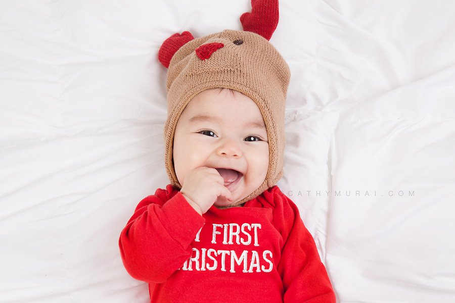 An adorable baby girl smiling and wearing my first christmas onesie, Cathy-Murai-Photography- Alhambra-South Pasadena-Pasadena-San Marino-San Gabriel Valley-Los Angeles-studio photography-Professional Christmas Photographer-Professional Christmas Photography, Christmas portrait photography Professional Christmas Photographer, Professional Christmas Photography, Baby Christmas portrait photography, Christmas baby photography, Christmas baby photography ideas, Christmas baby pictures