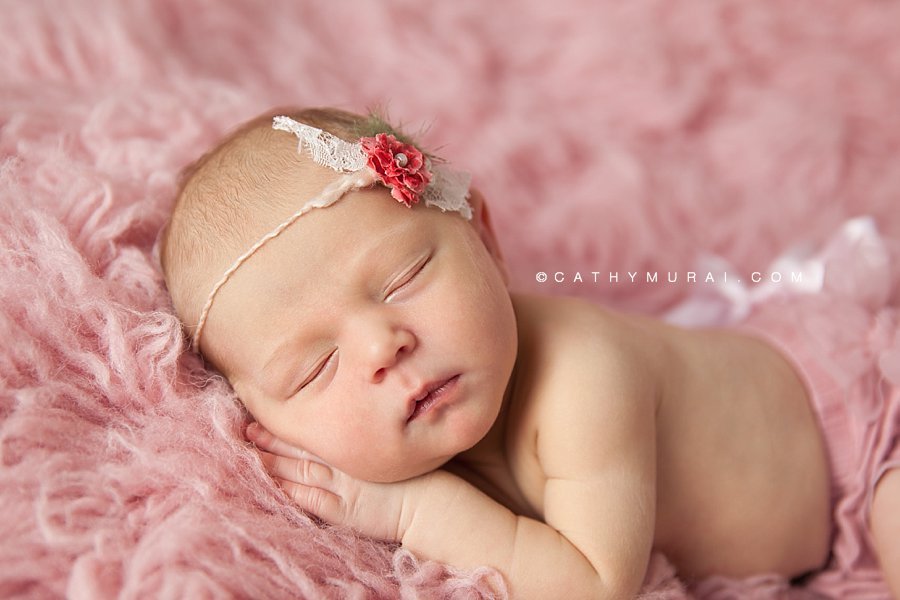 Newborn baby  girl  wearing a pink diaper cover and pink tie back, posing on the pink flokati rug,  Cathy Murai Photography, Los Angeles, Alhambra, South Pasadena, Pasadena, San Gabriel, San Marino Newborn Photographer