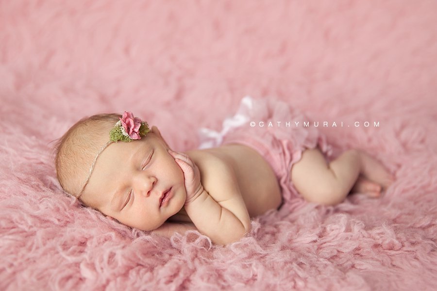 Newborn baby girl wearing a pink diaper cover and pink tie back, posing on the pink flokati rug, Cathy Murai Photography, Los Angeles, Alhambra, South Pasadena, Pasadena, San Gabriel, San Marino Newborn Photographer