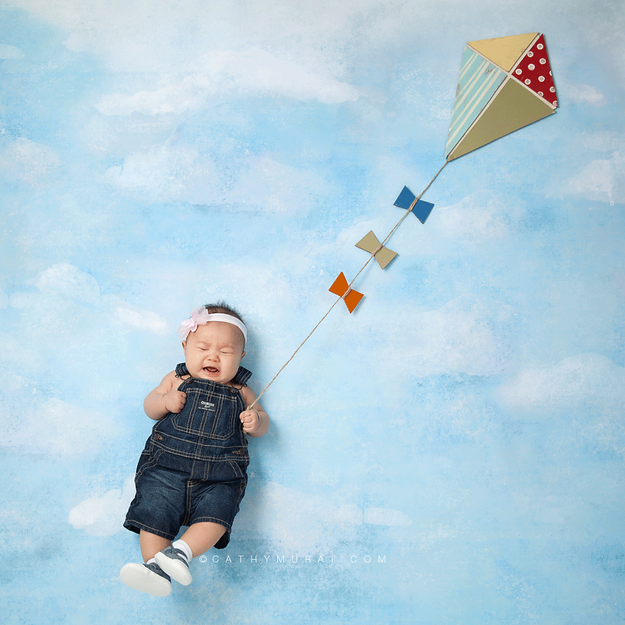 Crying 3 month old baby, Crying 3 months old baby girl holding a kite in the sky 