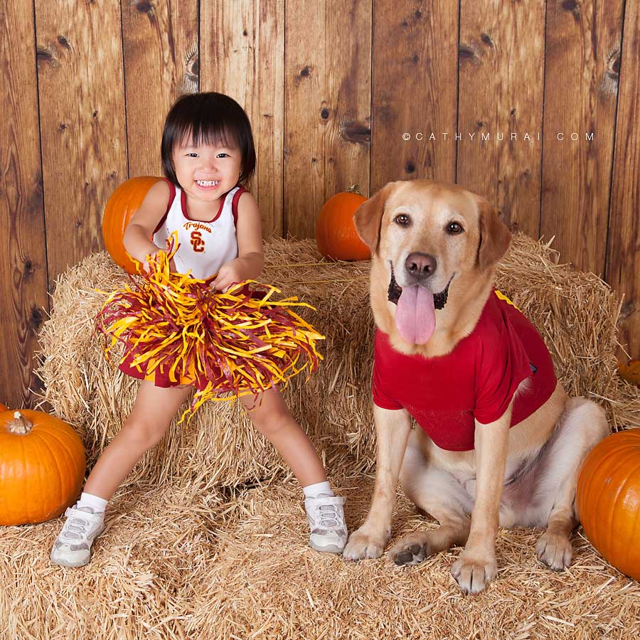 toddler in USC-Cheerleader costume and a dog in USC foot ball player costume, Los Angeles Halloween Photographer, Cathy Murai Photography