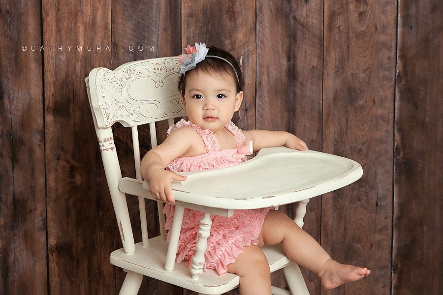 1st birthday girl wearing pink lace romper sitting on the cream vintage high chair in front of the wooden backdrop, LOS ANGELES Birthday Portraits, LOS ANGELES 1st Birthday Portraits, LOS ANGELES first Birthday pictures, LOS ANGELES Birthday Photographer, LOS ANGELES Birthday Photography, LOS ANGELES first Birthday Photography, LOS ANGELES first Birthday Photographer, LOS ANGELES 1st Birthday Photographer, , LOS ANGELES 1st Birthday Photography, LOS ANGELES Baby Photographer, LOS ANGELES Baby Photography, LOS ANGELES Family Photographer, LOS ANGELES Family Photography, Los Angeles Smash Cake, Los Angles Cake Smash, LA Birthday Portaits, LA 1st Birthday Portarits, LA first Birthday pictures, LA Birthday Photographer, LA Birthday Photography, LA first Birthday Photographer, LA first Birthday Photography, LA Baby Photographer, LA Baby Photography, LA Family Photographer, LA Family Photography, LA Smash Cake, LA Cake Smash, PASADENA Birthday Portraits, PASADENA 1st Birthday Portraits, PASADENA first Birthday pictures, PASADENA Birthday Photographer, PASADENA Birthday Photography, PASADENA first Birthday Photography, PASADENA first Birthday Photographer, PASADENA 1st Birthday Photographer, , PASADENA 1st Birthday Photography, PASADENA Baby Photographer, PASADENA Baby Photography, PASADENA Family Photographer, PASADENA Family Photography, Pasadena Smash Cake, Los Angles Cake Smash, SAN GABIEL VALLEY Birthday Portraits, SAN GABIEL VALLEY 1st Birthday Portraits, SAN GABIEL VALLEY first Birthday pictures, SAN GABIEL VALLEY Birthday Photographer, SAN GABIEL VALLEY Birthday Photography, SAN GABIEL VALLEY first Birthday Photography, SAN GABIEL VALLEY first Birthday Photographer, SAN GABIEL VALLEY 1st Birthday Photographer, , SAN GABIEL VALLEY 1st Birthday Photography, SAN GABIEL VALLEY Baby Photographer, SAN GABIEL VALLEY Baby Photography, SAN GABIEL VALLEY Family Photographer, SAN GABIEL VALLEY Family Photography, San Gabiel Valley Smash Cake, Los Angles Cake Smash, ALHAMBRA Birthday Portraits, ALHAMBRA 1st Birthday Portraits, ALHAMBRA first Birthday pictures, ALHAMBRA Birthday Photographer, ALHAMBRA Birthday Photography, ALHAMBRA first Birthday Photography, ALHAMBRA first Birthday Photographer, ALHAMBRA 1st Birthday Photographer, , ALHAMBRA 1st Birthday Photography, ALHAMBRA Baby Photographer, ALHAMBRA Baby Photography, ALHAMBRA Family Photographer, ALHAMBRA Family Photography, Alhambra Smash Cake, Los Angles Cake Smash, SAN MARINOBirthday Portraits, SAN MARINO1st Birthday Portraits, SAN MARINOfirst Birthday pictures, SAN MARINOBirthday Photographer, SAN MARINOBirthday Photography, SAN MARINOfirst Birthday Photography, SAN MARINOfirst Birthday Photographer, SAN MARINO1st Birthday Photographer, , SAN MARINO1st Birthday Photography, SAN MARINOBaby Photographer, SAN MARINOBaby Photography, SAN MARINOFamily Photographer, SAN MARINOFamily Photography, San MarinoSmash Cake, Los Angles Cake Smash, TEMPLE CITYBirthday Portraits, TEMPLE CITY1st Birthday Portraits, TEMPLE CITYfirst Birthday pictures, TEMPLE CITYBirthday Photographer, TEMPLE CITYBirthday Photography, TEMPLE CITYfirst Birthday Photography, TEMPLE CITYfirst Birthday Photographer, TEMPLE CITY1st Birthday Photographer, , TEMPLE CITY1st Birthday Photography, TEMPLE CITYBaby Photographer, TEMPLE CITYBaby Photography, TEMPLE CITYFamily Photographer, TEMPLE CITYFamily Photography, Temple CitySmash Cake, Los Angles Cake Smash, ROSEMEADBirthday Portraits, ROSEMEAD1st Birthday Portraits, ROSEMEADfirst Birthday pictures, ROSEMEADBirthday Photographer, ROSEMEADBirthday Photography, ROSEMEADfirst Birthday Photography, ROSEMEADfirst Birthday Photographer, ROSEMEAD1st Birthday Photographer, , ROSEMEAD1st Birthday Photography, ROSEMEADBaby Photographer, ROSEMEADBaby Photography, ROSEMEADFamily Photographer, ROSEMEADFamily Photography, RosemeadSmash Cake, Los Angles Cake Smash, DOWNTOWN LOS ANGELES Birthday Portraits, DOWNTOWN LOS ANGELES 1st Birthday Portraits, DOWNTOWN LOS ANGELES first Birthday pictures, DOWNTOWN LOS ANGELES Birthday Photographer, DOWNTOWN LOS ANGELES Birthday Photography, DOWNTOWN LOS ANGELES first Birthday Photography, DOWNTOWN LOS ANGELES first Birthday Photographer, DOWNTOWN LOS ANGELES 1st Birthday Photographer, , DOWNTOWN LOS ANGELES 1st Birthday Photography, DOWNTOWN LOS ANGELES Baby Photographer, DOWNTOWN LOS ANGELES Baby Photography, DOWNTOWN LOS ANGELES Family Photographer, DOWNTOWN LOS ANGELES Family Photography, Downtown Los Angeles Smash Cake, Los Angles Cake Smash