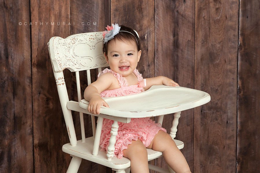 1st birthday girl wearing pink lace romper sitting on the cream vintage high chair in front of the wooden backdrop, LOS ANGELES Birthday Portraits, LOS ANGELES 1st Birthday Portraits, LOS ANGELES first Birthday pictures, LOS ANGELES Birthday Photographer, LOS ANGELES Birthday Photography, LOS ANGELES first Birthday Photography, LOS ANGELES first Birthday Photographer, LOS ANGELES 1st Birthday Photographer, , LOS ANGELES 1st Birthday Photography, LOS ANGELES Baby Photographer, LOS ANGELES Baby Photography, LOS ANGELES Family Photographer, LOS ANGELES Family Photography, Los Angeles Smash Cake, Los Angles Cake Smash, LA Birthday Portaits, LA 1st Birthday Portarits, LA first Birthday pictures, LA Birthday Photographer, LA Birthday Photography, LA first Birthday Photographer, LA first Birthday Photography, LA Baby Photographer, LA Baby Photography, LA Family Photographer, LA Family Photography, LA Smash Cake, LA Cake Smash, PASADENA Birthday Portraits, PASADENA 1st Birthday Portraits, PASADENA first Birthday pictures, PASADENA Birthday Photographer, PASADENA Birthday Photography, PASADENA first Birthday Photography, PASADENA first Birthday Photographer, PASADENA 1st Birthday Photographer, , PASADENA 1st Birthday Photography, PASADENA Baby Photographer, PASADENA Baby Photography, PASADENA Family Photographer, PASADENA Family Photography, Pasadena Smash Cake, Los Angles Cake Smash, SAN GABIEL VALLEY Birthday Portraits, SAN GABIEL VALLEY 1st Birthday Portraits, SAN GABIEL VALLEY first Birthday pictures, SAN GABIEL VALLEY Birthday Photographer, SAN GABIEL VALLEY Birthday Photography, SAN GABIEL VALLEY first Birthday Photography, SAN GABIEL VALLEY first Birthday Photographer, SAN GABIEL VALLEY 1st Birthday Photographer, , SAN GABIEL VALLEY 1st Birthday Photography, SAN GABIEL VALLEY Baby Photographer, SAN GABIEL VALLEY Baby Photography, SAN GABIEL VALLEY Family Photographer, SAN GABIEL VALLEY Family Photography, San Gabiel Valley Smash Cake, Los Angles Cake Smash, ALHAMBRA Birthday Portraits, ALHAMBRA 1st Birthday Portraits, ALHAMBRA first Birthday pictures, ALHAMBRA Birthday Photographer, ALHAMBRA Birthday Photography, ALHAMBRA first Birthday Photography, ALHAMBRA first Birthday Photographer, ALHAMBRA 1st Birthday Photographer, , ALHAMBRA 1st Birthday Photography, ALHAMBRA Baby Photographer, ALHAMBRA Baby Photography, ALHAMBRA Family Photographer, ALHAMBRA Family Photography, Alhambra Smash Cake, Los Angles Cake Smash, SAN MARINOBirthday Portraits, SAN MARINO1st Birthday Portraits, SAN MARINOfirst Birthday pictures, SAN MARINOBirthday Photographer, SAN MARINOBirthday Photography, SAN MARINOfirst Birthday Photography, SAN MARINOfirst Birthday Photographer, SAN MARINO1st Birthday Photographer, , SAN MARINO1st Birthday Photography, SAN MARINOBaby Photographer, SAN MARINOBaby Photography, SAN MARINOFamily Photographer, SAN MARINOFamily Photography, San MarinoSmash Cake, Los Angles Cake Smash, TEMPLE CITYBirthday Portraits, TEMPLE CITY1st Birthday Portraits, TEMPLE CITYfirst Birthday pictures, TEMPLE CITYBirthday Photographer, TEMPLE CITYBirthday Photography, TEMPLE CITYfirst Birthday Photography, TEMPLE CITYfirst Birthday Photographer, TEMPLE CITY1st Birthday Photographer, , TEMPLE CITY1st Birthday Photography, TEMPLE CITYBaby Photographer, TEMPLE CITYBaby Photography, TEMPLE CITYFamily Photographer, TEMPLE CITYFamily Photography, Temple CitySmash Cake, Los Angles Cake Smash, ROSEMEADBirthday Portraits, ROSEMEAD1st Birthday Portraits, ROSEMEADfirst Birthday pictures, ROSEMEADBirthday Photographer, ROSEMEADBirthday Photography, ROSEMEADfirst Birthday Photography, ROSEMEADfirst Birthday Photographer, ROSEMEAD1st Birthday Photographer, , ROSEMEAD1st Birthday Photography, ROSEMEADBaby Photographer, ROSEMEADBaby Photography, ROSEMEADFamily Photographer, ROSEMEADFamily Photography, RosemeadSmash Cake, Los Angles Cake Smash, DOWNTOWN LOS ANGELES Birthday Portraits, DOWNTOWN LOS ANGELES 1st Birthday Portraits, DOWNTOWN LOS ANGELES first Birthday pictures, DOWNTOWN LOS ANGELES Birthday Photographer, DOWNTOWN LOS ANGELES Birthday Photography, DOWNTOWN LOS ANGELES first Birthday Photography, DOWNTOWN LOS ANGELES first Birthday Photographer, DOWNTOWN LOS ANGELES 1st Birthday Photographer, , DOWNTOWN LOS ANGELES 1st Birthday Photography, DOWNTOWN LOS ANGELES Baby Photographer, DOWNTOWN LOS ANGELES Baby Photography, DOWNTOWN LOS ANGELES Family Photographer, DOWNTOWN LOS ANGELES Family Photography, Downtown Los Angeles Smash Cake, Los Angles Cake Smash