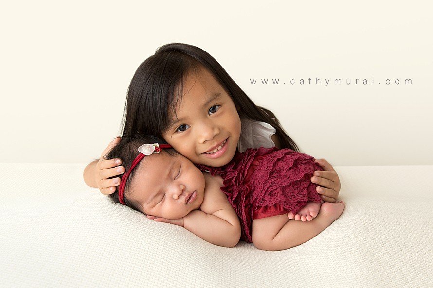newborn girl photography and newborn photography with sibling (big sister) captured by Cathy Murai Photography, an Orange County Newborn Baby photographer who specializes in newborn photography poses