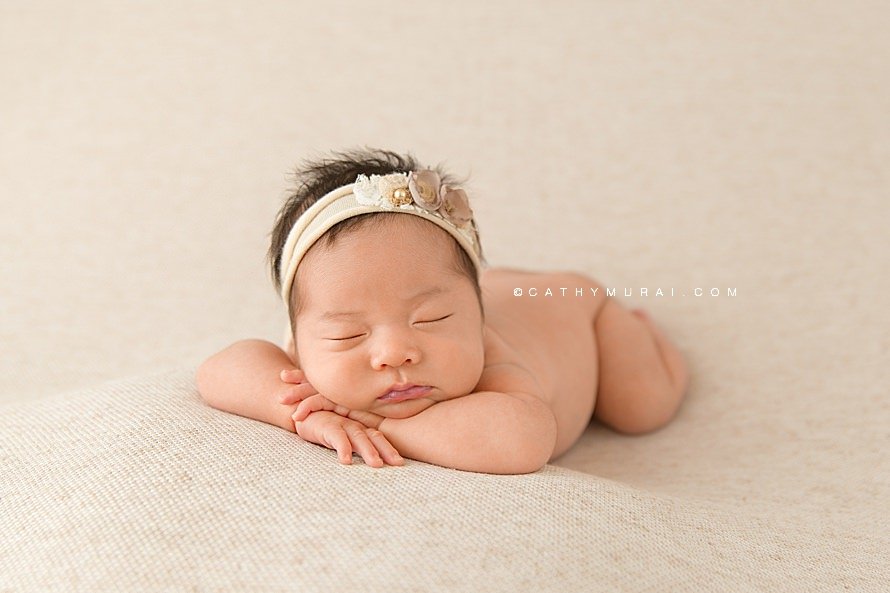 Natural Organic Newborn photography Session by Cathy Murai Photography, Orange County Newborn and baby photographer in Irvine, a newborn baby girl wearing a cream headband is in Chin on Hands Pose.jpg
