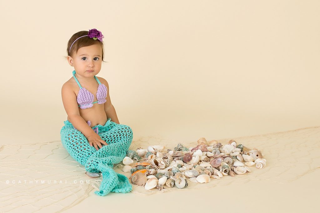 First birthday girl with mermaid props during her mermaid themed first birthday photoshoot with
Cathy Murai Photography, a Irvine baby photographer
