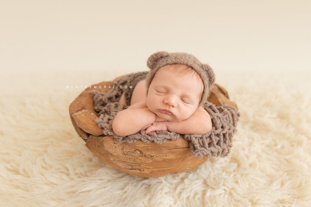 Newborn Props like this wooden basket, blanket, and hat play a big role in preparing for a photoshoot