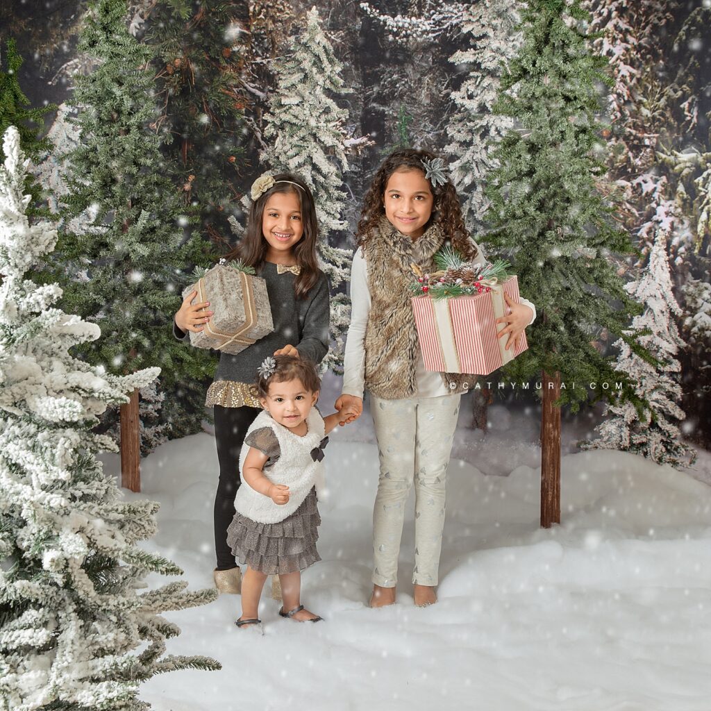 2020 Holiday mini sessions Orange County let it snow -  Holiday mini photo sessions near me, Holiday mini sessions near me, 2020 Christmas Mini Sessions - Siblings holiday photo in a winter snowfall Christmas tree farm set up in studio in Irvine, CA