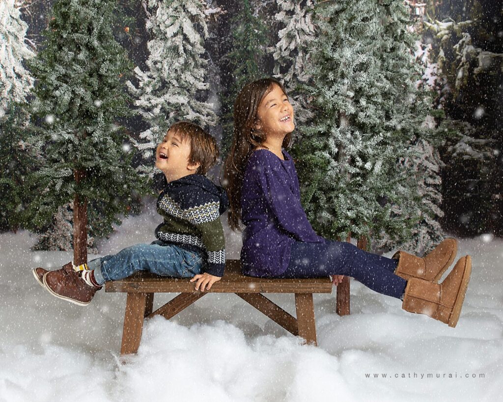 Holiday mini photo sessions near me Cathy Murai Photography captured these happy siblings while using a snow machine during holiday mini sessions in Orange County. 2020 Christmas mini photo session in Irvine, CA