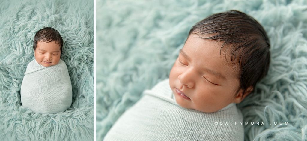 Newborn baby boy swaddled in a teal wrap laying on a furry, teal background during his newborn photo session with Cathy Murai Photography, orange county newborn photographer, in her studio in Irvine